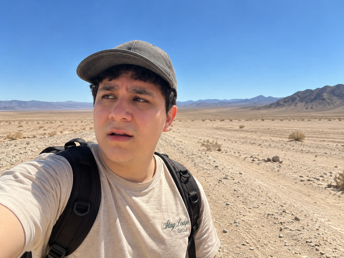 Selfie del beneficiario, solo, en medio de un desierto vacío con montañas al fondo